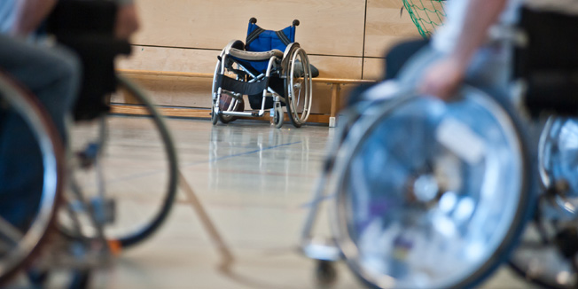 Rollstuhlfahrer - im Hintergrund leerer Rollstuhl