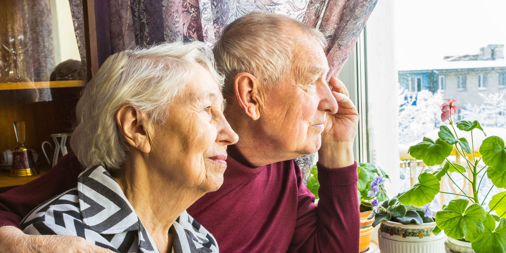 Älteres Paar schaut aus dem Fenster