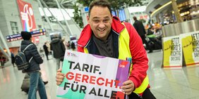 Thomas Ziegler mit Schild "Tarif. Gerecht. Für alle." am Düsseldorfer Flughafen 8.10.2019