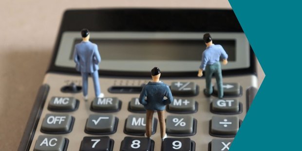Drei Miniaturfiguren stehen auf einem Taschenrechner und schauen auf das leere Display