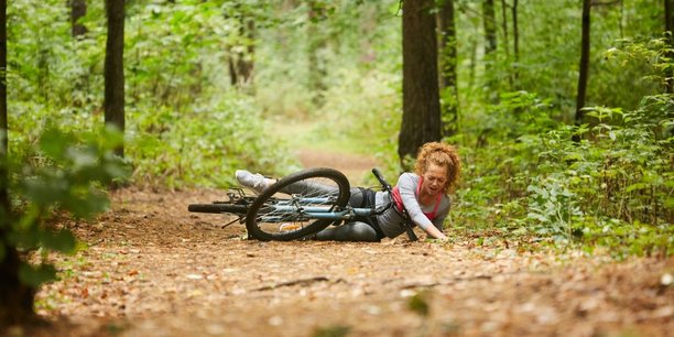Unfall Frau mit Fahrrad im Wald in der Freizeit