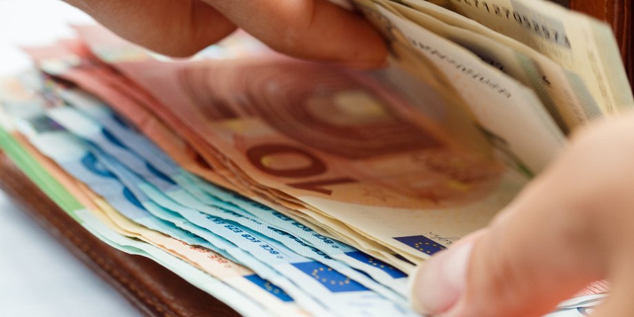 Hand an offener Geldbörse mit Euro-Scheinen