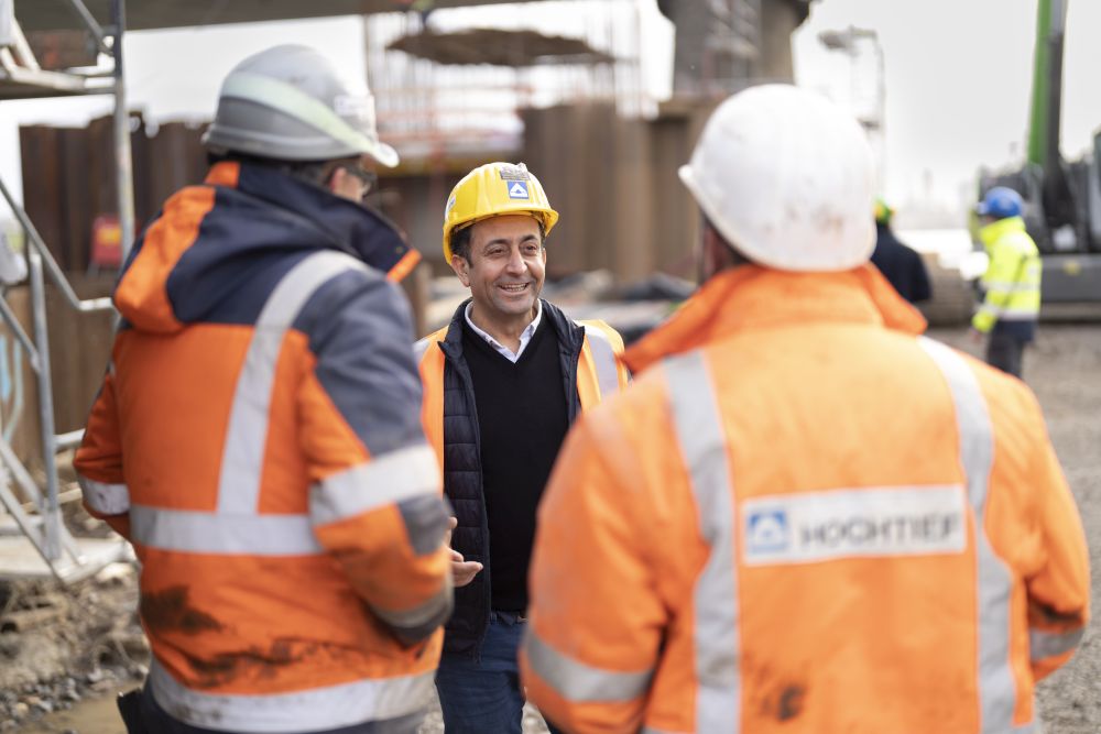 Betriebsrat Mehmet Perisan im Gespräch mit Beschäftigten auf der Baustelle