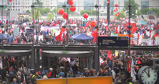 Menschenmassen im Foyer des Berliner Hauptbahnhof mir roten Luftballons und Plakaten