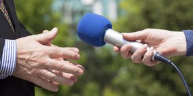 Interview mit zwei Personen mit blauen Mikrofon