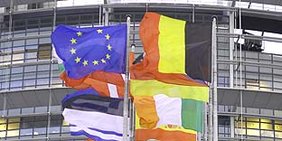 EU-Flagge und die Flaggen der Mitgliedsstaaten der EU wehend vor dem Gebäude des EU-Parlaments