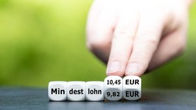 Hand würfelt und ändert den mindestlohn 9,82 Euro Mindestlohn 10,45 Euro