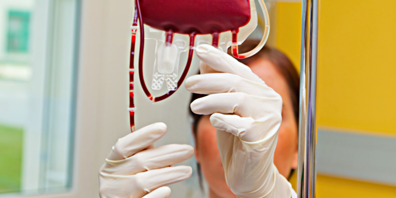 Krankenschwester hängt Behälter mit Bluttransfusion / Blutspende auf; Symbolbild Gesundheit / Kramkheit / Krankenhaus
