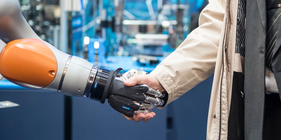 Digitale Arbeit Symbolbild: Roboterhand schüttelt Menschenhand