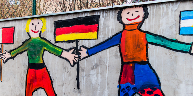 Malerei von Kindern auf Wand: Kinder mit Flaggen unterschiedlicher Länder Hand in Hand