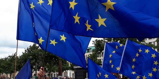 Mehrere Europafahnen wehen auf einer Demonstration im Wind