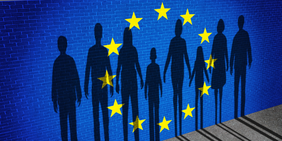 Europäische Flagge auf einer Mauer mit Schatten einer Menschenkette