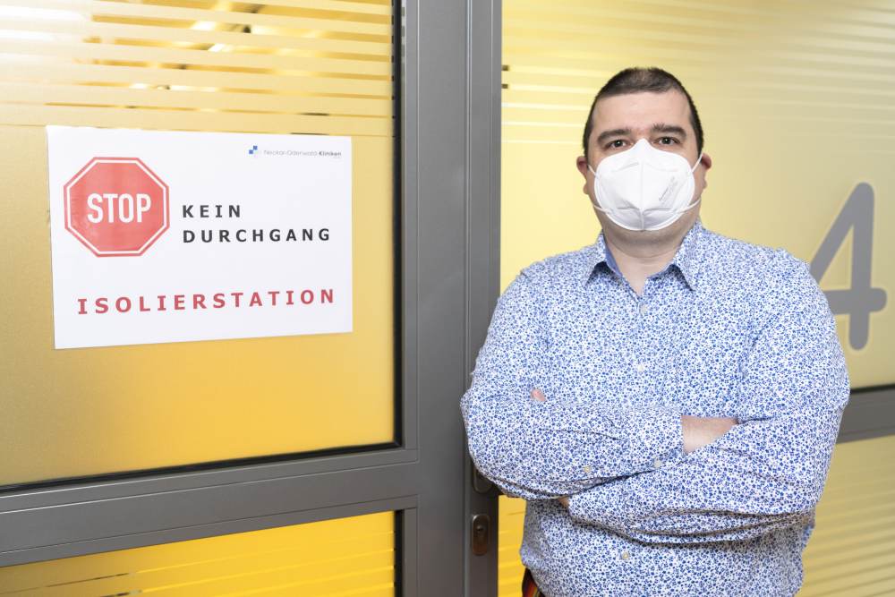 Betriebsrat Simon Schreiweis mit Maske vor der Isolierstation der Klinik.