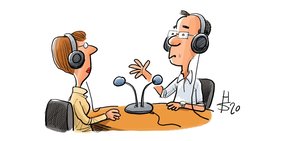 Karikatur mit einem Mann und einer Frau die an einem Tisch sitzen, auf dem Mikrofone stehen.