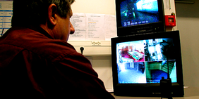 Detektiv / Arbeitgeber vor Bildschirmen, Videoüberwachung