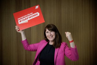 Foto von Stefanie Geyer, die ein rotes Schild in der Hand hält mir der Aufschrift "Eintreten für die #Tarifwende".