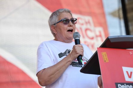 Elke Hannack spricht bei der DGB-Kundgebung in Leipzig ins Mikrofon. Sie trägt ein weißes „Hart verdient!“-Shirt.