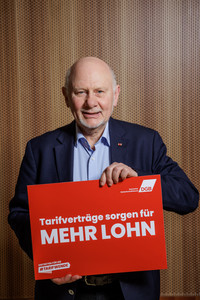 Franz Düwell, der ein Plakat hält mit der Aufschrift "Tarifverträge sorgen für mehr Lohn"