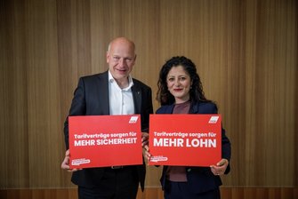 Foto von Kai Wegner (CDU) und Canzel Kiziltepe (SPD), die jeweils ein rotes Schild halten mit den Aufschriften "Tarifverträge sorgen für mehr Sicherheit" und "Tarifverträge sorgen für mehr Lohn".