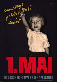 Maiplakat des DGB von 1956: Ein kleiner Junge von etwa 5 Jahren zeigt mit der rechten Hand senkrecht nach oben. Darüber stehte "Samstags gehört Vati mir".  Darunter "1. Mai Deutscher Gewerkschaftsbund". Der Junge trägt ein weißes T-Shirt und steht vor einem schwarzen Hintergrund.