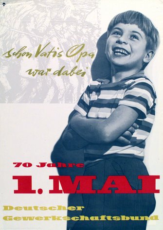 Maiplakat 1960:  Text "schon Vatis Opa war dabei. 70 Jahre 1. Mai. Deutscher Gewerkschaftsbund". Motiv: Ein Junge von etwa 8 bis 10 Jahren mit quer-gestreiftem T-Shirt lehnt lachend mit verschränkten Armen an einer Mauer.