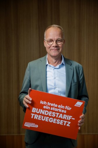 Foto von Matthias Miersch (SPD), der ein Schild in der Hand hält mit der Aufschrift "Ich trete ein für ein starkes Bundestariftreuegesetz".