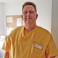 Portraitfoto von einem OP-Pfleger in Arbeitskleidung