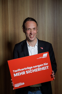 Portrait von Pascal Meiser, ehemaliger Bundestagsabgeordneter für Die Linke, der ein Plakat hält mit der Aufschrift "Tarifverträge sorgen für mehr Sicherheit"