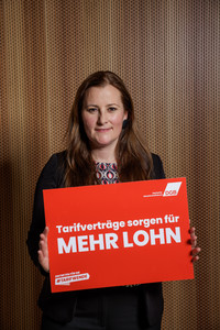 Foto von Janine Wissler, die ein Plakat hält mit der Aufschrift "Tarifverträge sorgen für mehr Lohn"