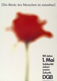 Plakat 1. Mai 1990: Text: 100 Jahre 1. Mai. Solidarität sichert unsere Zukunft. DGB. Motiv: Im Hintergrund eine rote Nelke, mittig und unscharf auf beigen Grund.