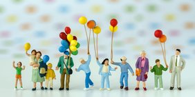 Mehrere Miniatur-Figuren mit Luftballons